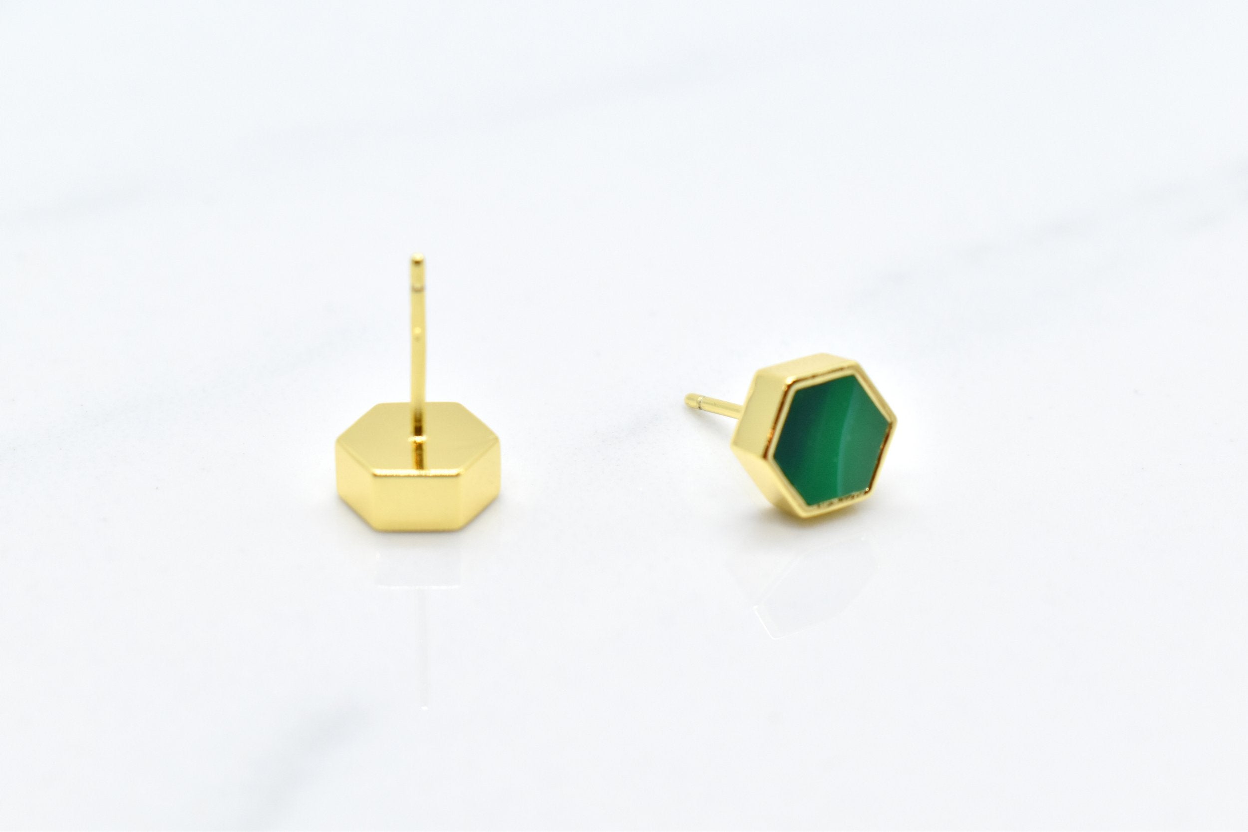 gold hexagon studs with back of stud and sterling silver posts that are hypoallergenic shown against a white background, includes 14k gold plated earrings with emerald gem clay