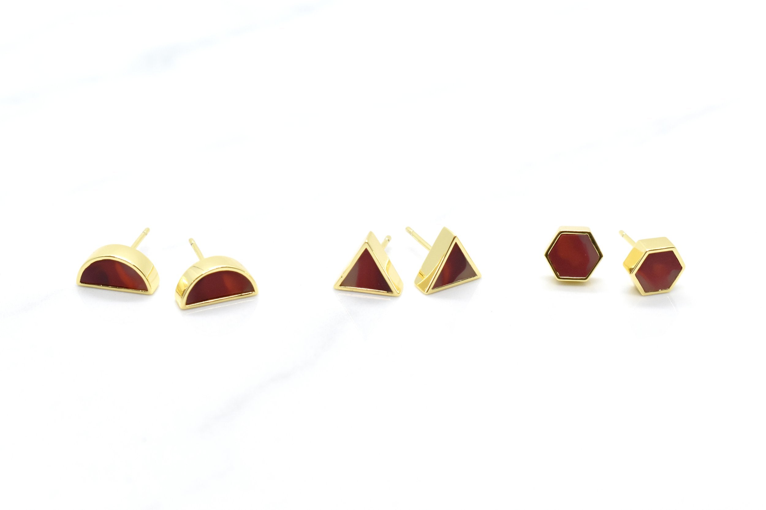 set of three geometric stud earrings in hexagons triangles and half moon shapes all filled with hand marbled garnet gemstone clay, looks like ruby earrings
