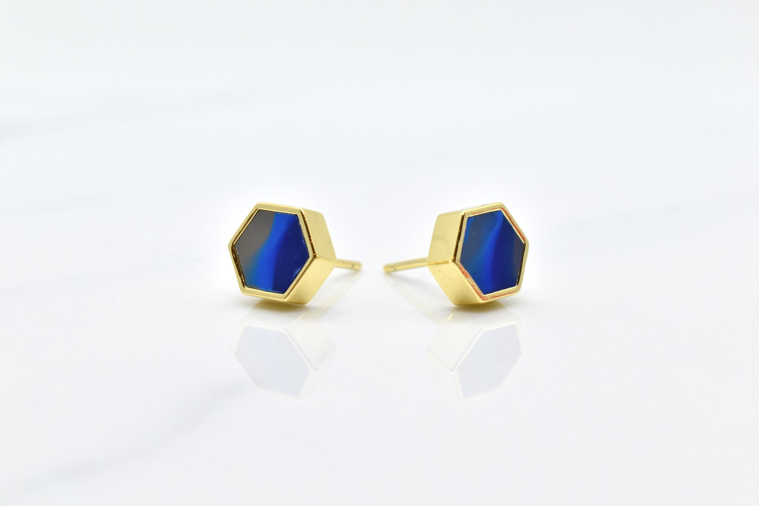 blue and gold hexagon stud earring set with swirling sapphire texture and 14k gold hexagon shape against a white background