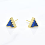 gold triangle stud earring set in sapphire gemstone like clay against a white background
