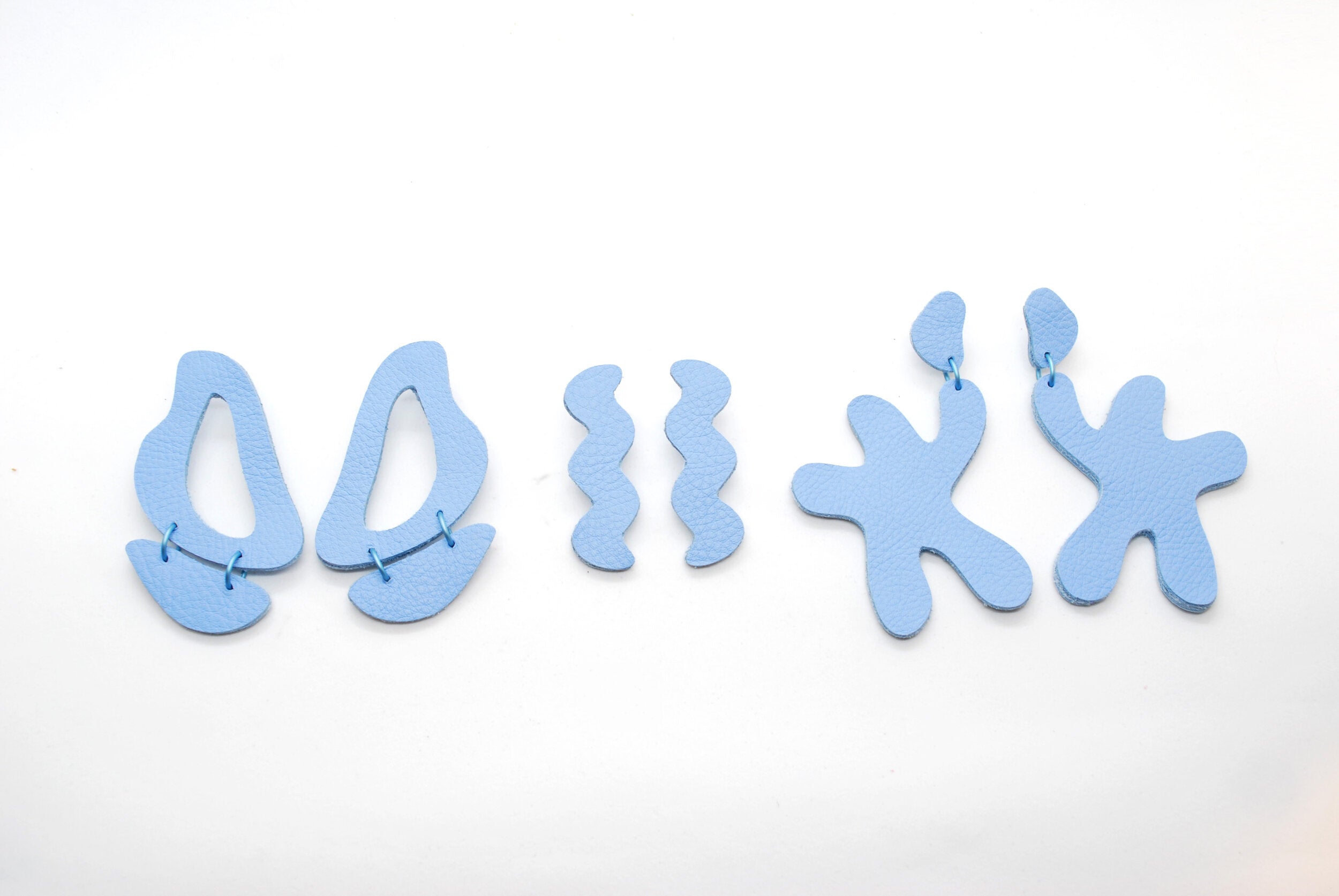 three pairs of irregular shape oversized statement earrings in baby blue.