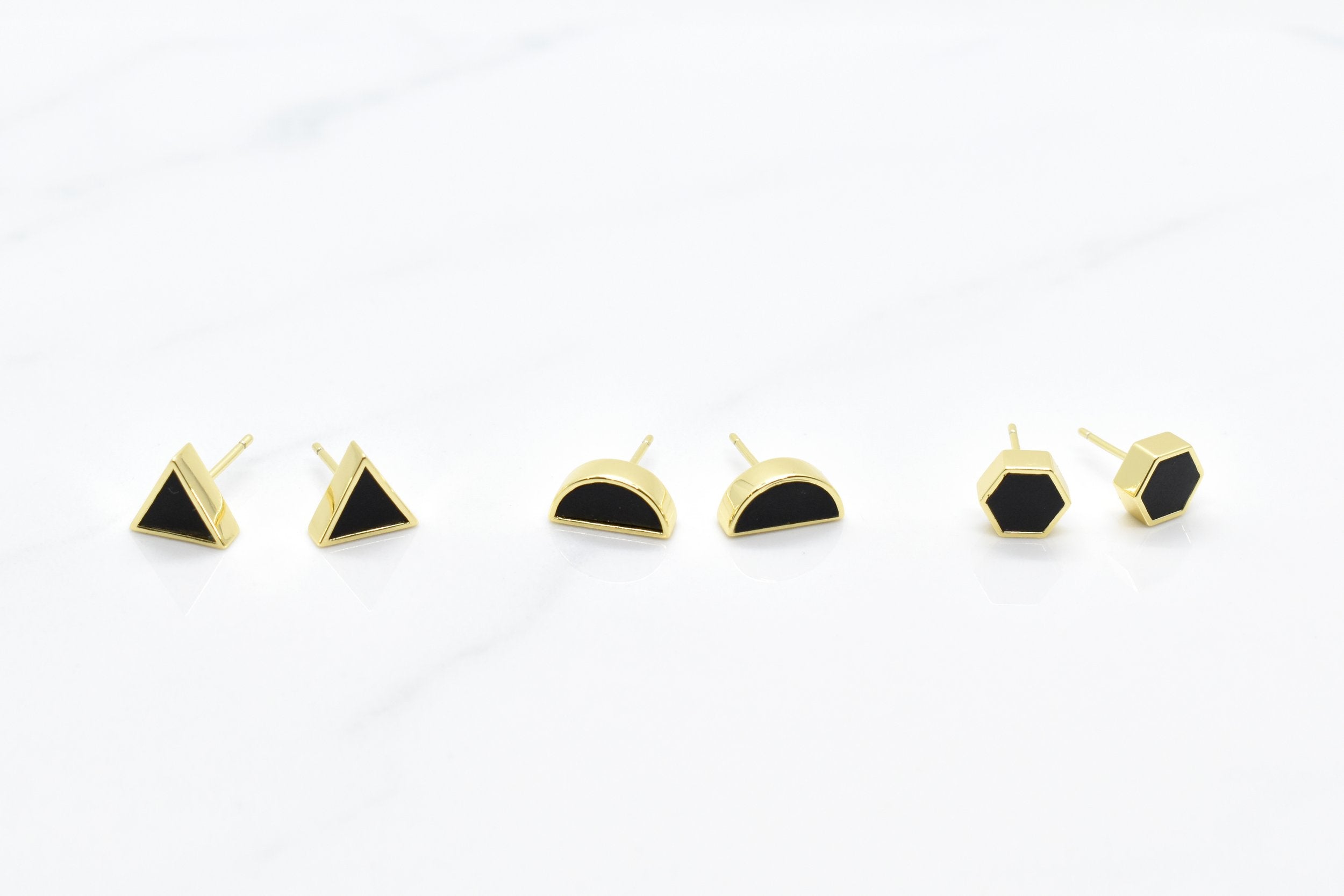a white background featuring three pairs of modern geometric stud earring sets that loom like black hexagon earrings stud set with gold plated silver 925 hexagon shape