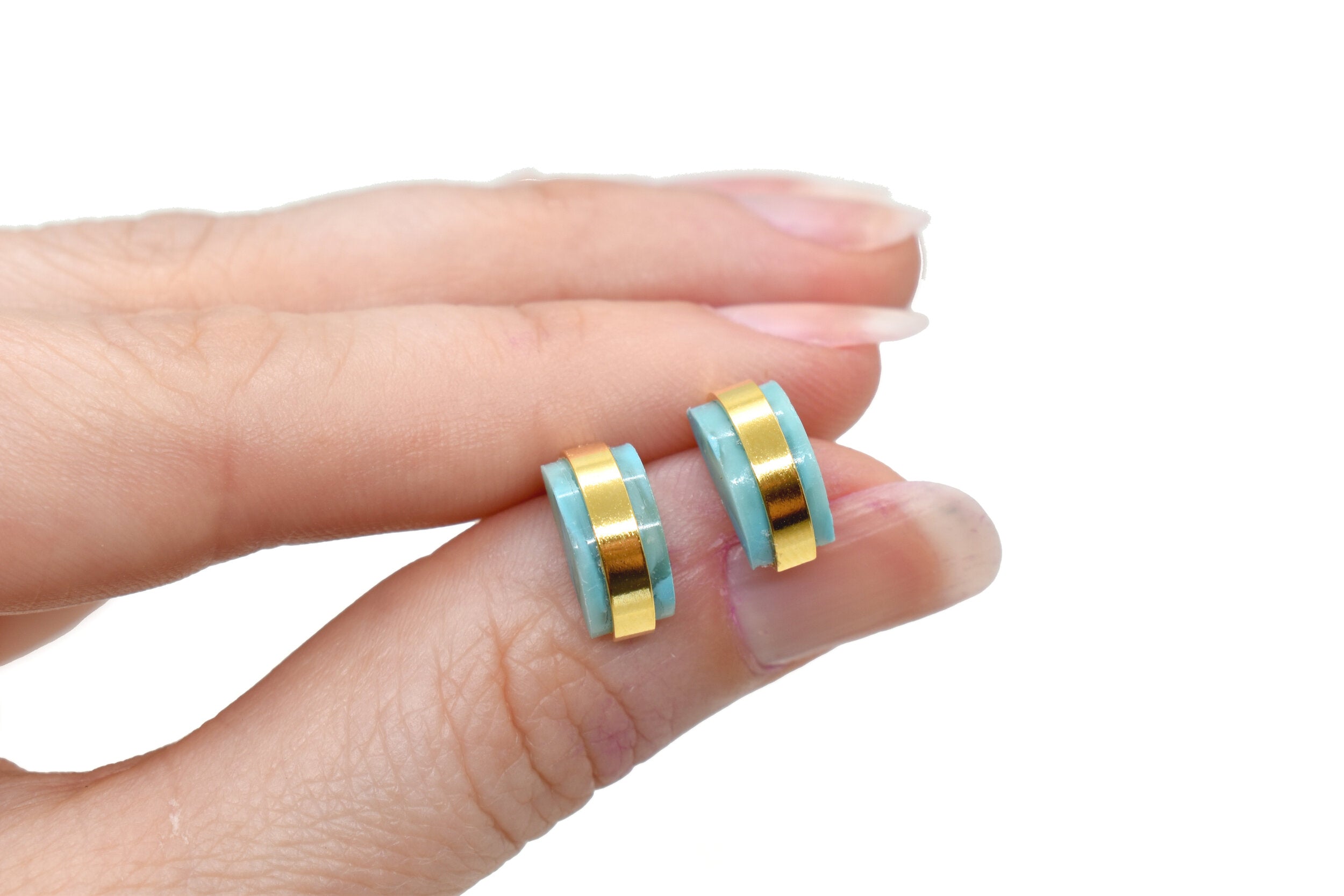 hand holding modern architectural small stud earring set birthstone jewelry march aqua gemstone
