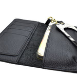 inside of black leather catch all wallet with phone tucked in pocket