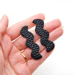 big, bold leather cutout earrings in space black.
