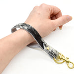key chain loop in speckled black hair on hide leather with gold key ring and gold clasp.
