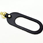 A dual-sided leather multicolor keychain in black saddle leather black and white hair-on-hide leather