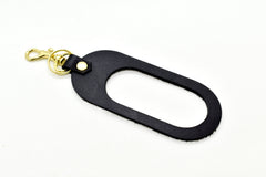 A dual-sided leather multicolor keychain in black saddle leather black and white hair-on-hide leather