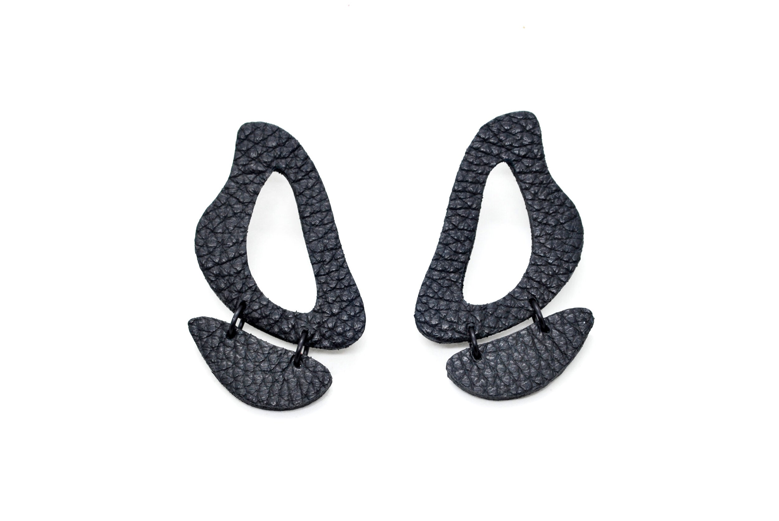 black leather earrings made of cutout organic shapes and anodized aluminum jump rings.