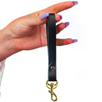 hand holding black saddle leather keychain wristlet strap for cowgirls wrist strap leather key fob black leather  accessory
