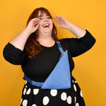 person laughing and wearing a matisse inspired leather sling bag in modern style accessories