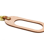 oval leather keychain in shiny metallic rose gold leather and chestnut brown saddle leather finish