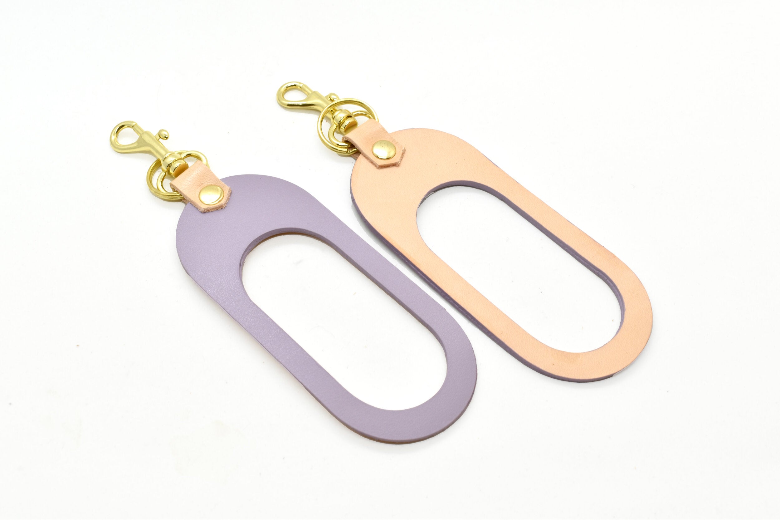 A dual-sided leather multicolor keychain in veg tan leather and matte pastel purple leather.
