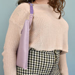 woman wearing a lavender sling purse on her shoulder