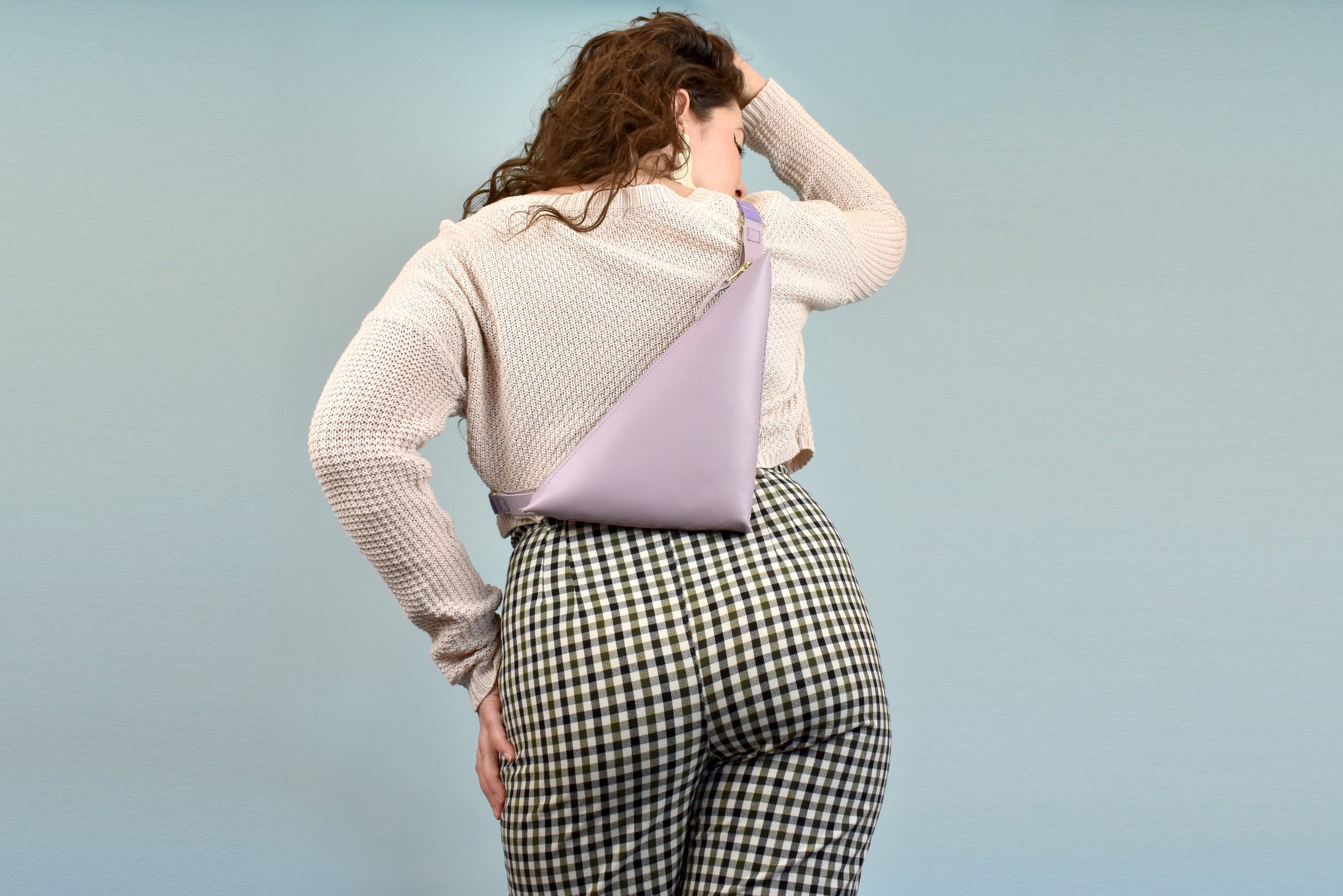 woman shown from the back wearing a small lightweight crossbody bag perfect for trip to park hiking adventure