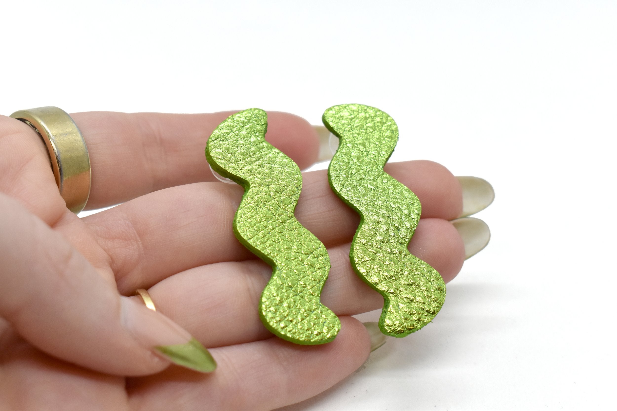 hand holding Metallic Lime Green Zigzag Statement Earrings, Metallic Leather Matisse Earrings
