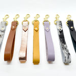 modern and minimal saddle leather equestrian style wristlet keychains in neutral and bright colors.