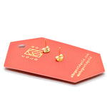 the back of a red card showing a set of gold studs with ruby stone that is marbled polymer clay