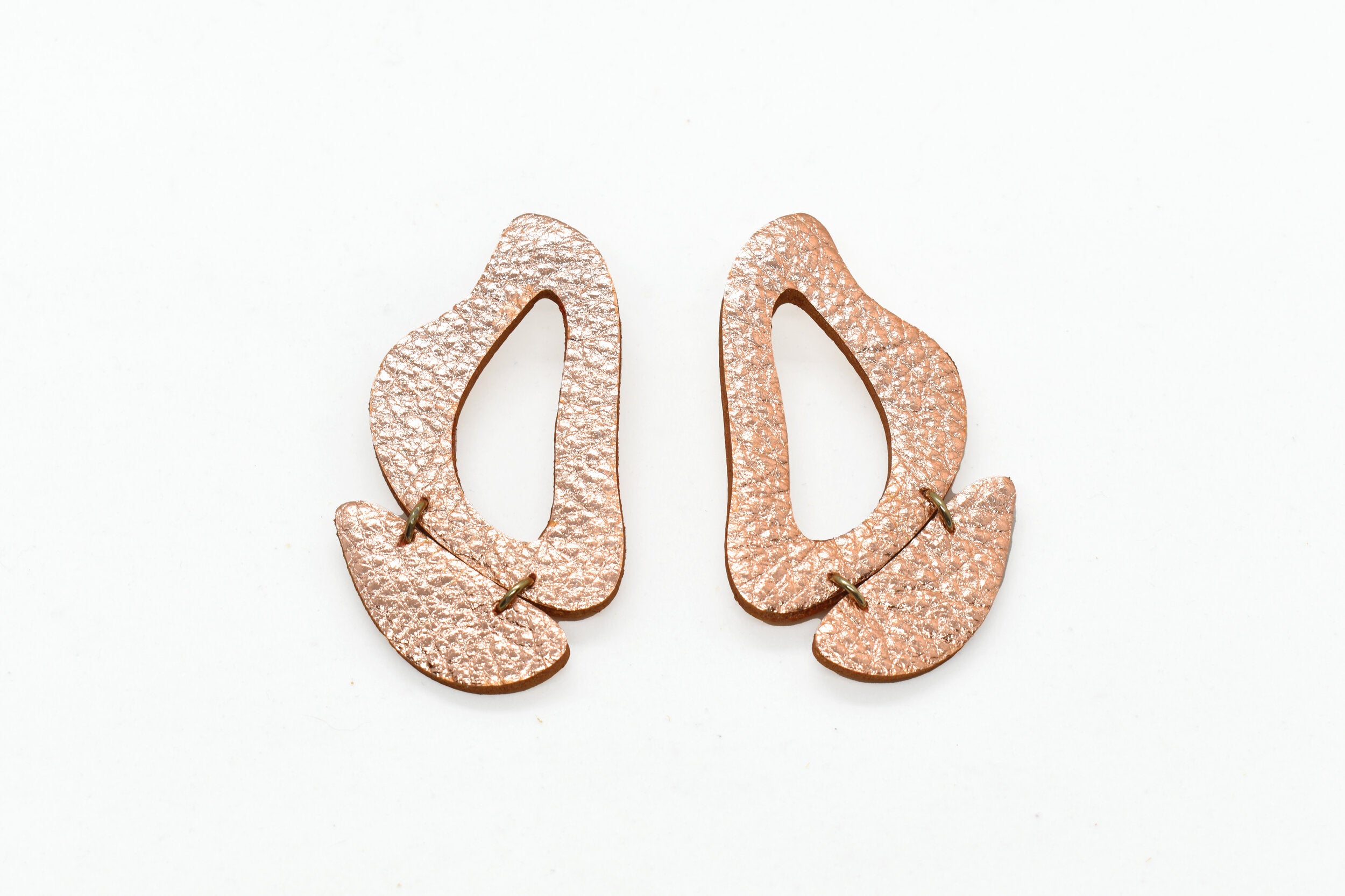 metallic rose gold leather earrings made of cutout organic shapes and anodized aluminum jump rings.