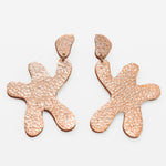 star shaped linked dangle earrings in shimmering rose gold leather.