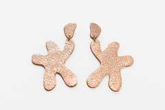 star shaped linked dangle earrings in shimmering rose gold leather.